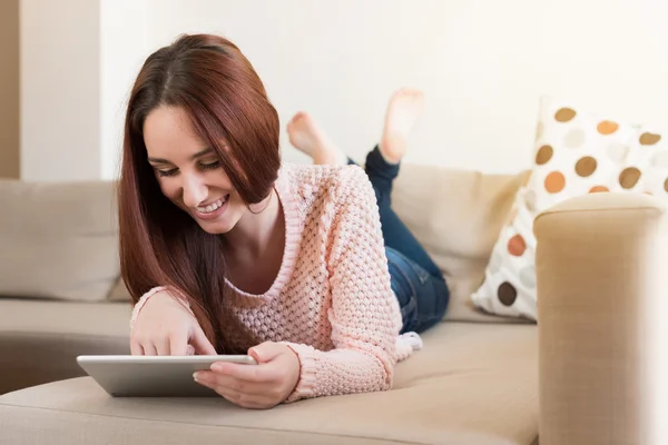 Mulher no sofá com tablet — Fotografia de Stock