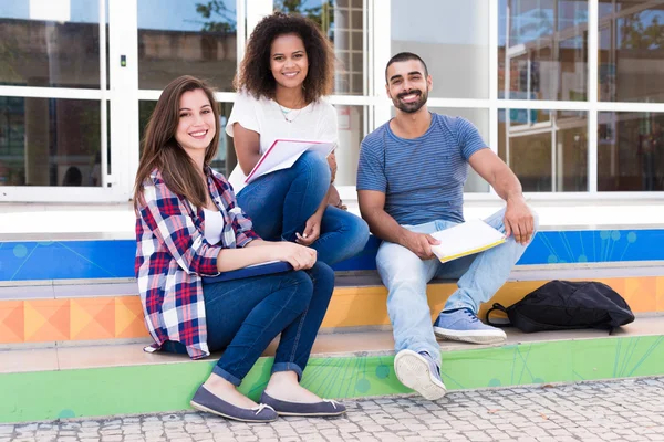 Estudantes sentados nas escadas da escola — Fotografia de Stock