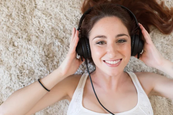 Vrouw met hoofdtelefoon te leggen — Stockfoto