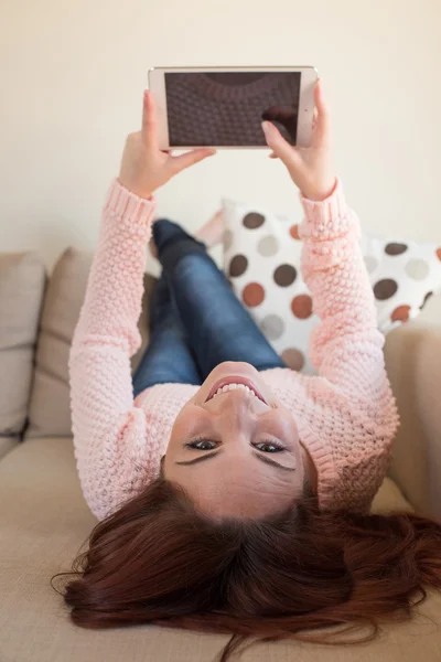 Mulher no sofá com tablet — Fotografia de Stock