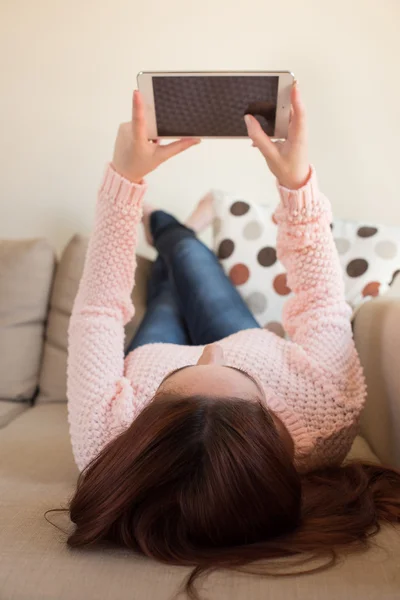 Mulher no sofá com tablet — Fotografia de Stock