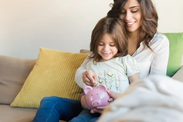 Mãe e filha economizando dinheiro — Fotografia de Stock