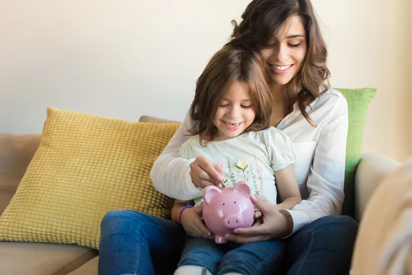 Moeder en dochter geld te besparen — Stockfoto