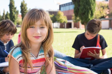 çimenlerin üzerinde oturan öğrenciler
