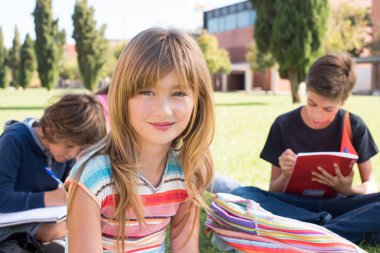 çimenlerin üzerinde oturan öğrenciler