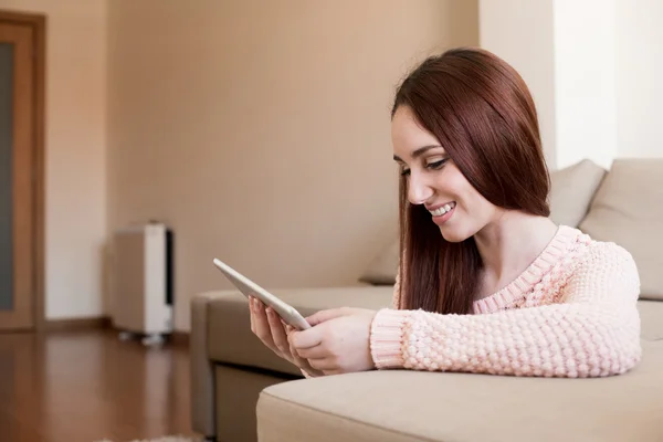 Mujer en sofá con la tableta — Foto de Stock