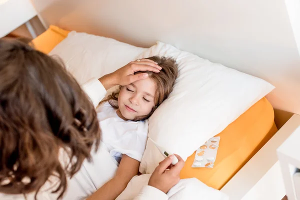 Moeder van zieke dochter verzorgen — Stockfoto