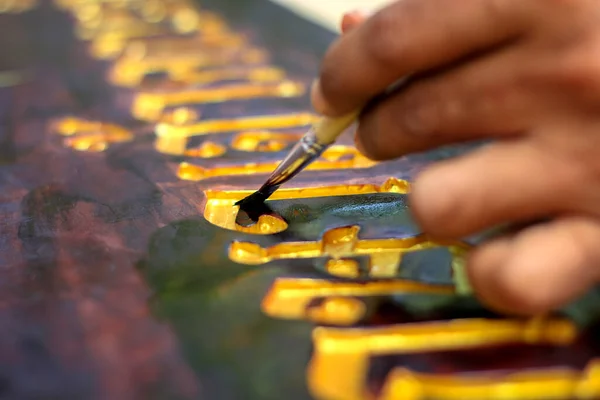 Close Mão Homem Segurando Pincel Dourado Tinta Sinais Letras Chão Fotografias De Stock Royalty-Free