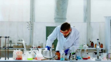 Laboratuvar uzmanı yangına kimyasal reaksiyon eklemiş ve bilim adamının laboratuarında kameranın önünde yangın gösterisi yapmış.