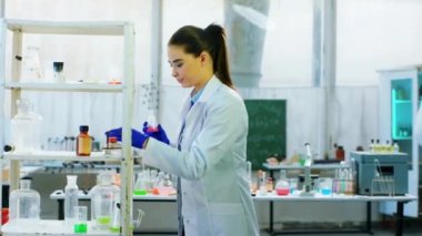 Biyoteknoloji laboratuvarındaki kadın ve adam cam küvette kimyasal reaksiyon kullanarak virüsler üzerinde test yapıyorlar. ARRI Alexa Mini 'de çekilen.