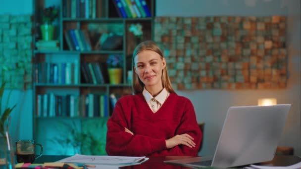 Blondynka studentka robi swój projekt na studiach używając laptopa. Napisała coś na papierze. — Wideo stockowe