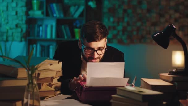 In der Bibliothek macht der Geschichtsstudent sein Projekt mit einer alten Schreibmaschine, während er in einer kleinen Pause ein Papierflugzeug nimmt und vor der Kamera spielt — Stockvideo