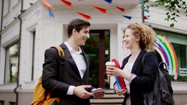 Pria tampan dan wanita cantik memiliki percakapan yang indah setelah bekerja di depan gedung bisnis mereka membahas sesuatu yang pria berikan kepada rekannya secangkir kopi. 4k — Stok Video