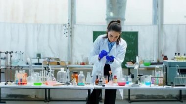 Laboratuvarda çalışan bilim adamı cam küvet üzerinde test ettikleri aşıyı araştırıyor konsantre ve birlikte çalışırken heyecanlanıyor.