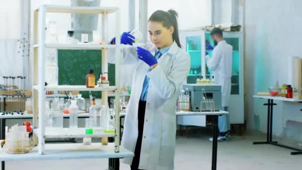 Közelkép a kamera előtt a kémia laborban hölgy és férfi tudósok dolgoznak néhány kísérleten nagyon koncentrált — Stock videók