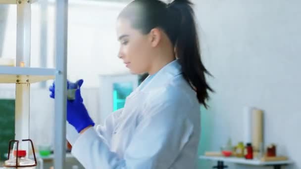 Karizmatikus tudós hölgy és férfi a retro laborban együtt dolgoznak, elemzik az üvegkád kémiai reakciójának eredményeit. — Stock videók