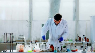 Kameranın önünde karizmatik bir laboratuvar adamı güzel havai fişekler yapmak için barut kullanarak bazı deneyler yapıyor. 4k