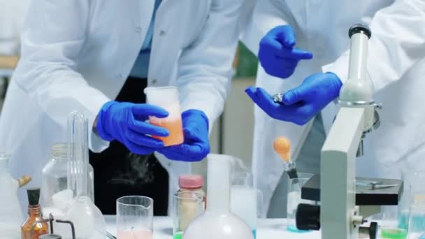 생화학 실험실에 있는 두 명 의학생 이 실시 한 화학 실험의 세부 사항으로 대학 프로젝트를 위해 실험을 하고 있다. ARRI 알렉사 미니 촬영. — 비디오
