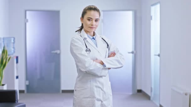 Modern sjukhus korridor lysande attraktiv läkare kvinna poserar framför kameran har korsade händer. 4k — Stockvideo