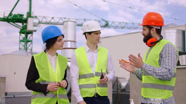 Good looking man businessman his assistant and architect analyzing the next plan of construction site on the roof top of the building they wearing protective mask — Stock Video