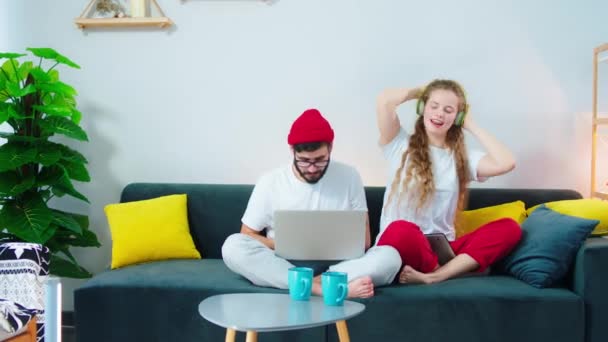 Voor de camera een mooie charismatische vrouw die geniet van de tijd naast haar partner man terwijl ze op de bank zitten nemen ze wat foto 's van de telefoon voor herinneringen. Neergeschoten op ARRI Alexa — Stockvideo