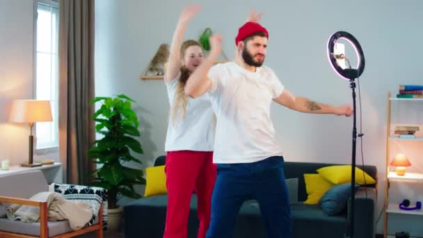 Pareja muy atractiva y divertida grabando un baile divertido para la cuenta de redes sociales usando anillo de luz y teléfono — Vídeos de Stock