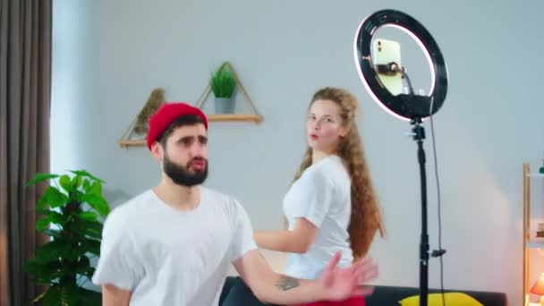 Closeup στην κάμερα νεαρό ζευγάρι απολαμβάνοντας το χρόνο στο σπίτι στο σαλόνι που χρησιμοποιούν φως δωμάτιο και την καταγραφή αστείο βίντεο για λογαριασμό κοινωνικών μέσων μαζικής ενημέρωσης — Αρχείο Βίντεο