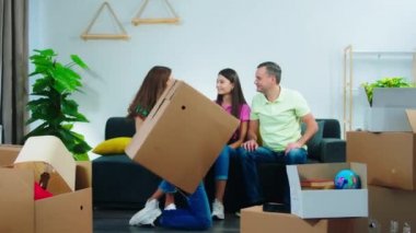 Mutlu ve heyecanlı ailenin yeni bir evi var. Oturma odasındaki kanepede oturuyorlar ve yeni evlerinin tadını çıkarıyorlar. Küçük çocuk evin anahtarını alıp ailesine veriyor.