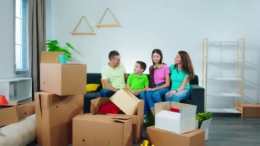 Çekici bir aile yeni bir eve taşındı. Oturma odasındaki kanepede oturmuş büyük bir gülümsemeyle anın tadını çıkarırken çok heyecanlılar.