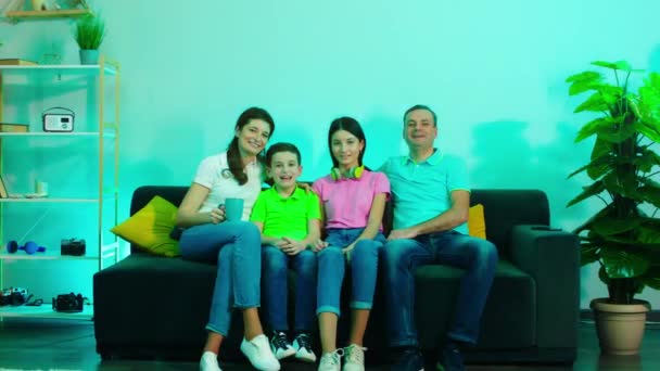 Mosolygó nagy boldog család a kanapén a nappaliban TV-t néznek élvezik az időt együtt — Stock videók