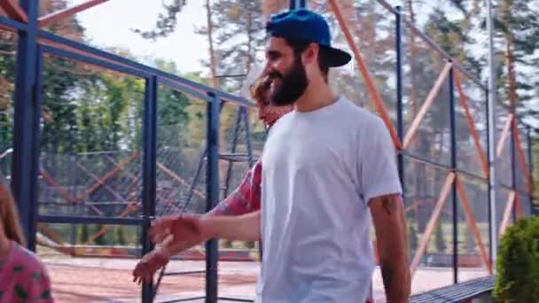 Di taman skate perkotaan dua pria karismatik bertemu pacar mereka di taman mereka mulai bersosialisasi sementara para wanita minum kopi — Stok Video