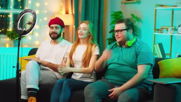 Karismatisk och attraktiv dam och hennes vänner sociala medier influencers gör en live stream för sociala medier konto de spelar in video från smartphone och med hjälp av en ljusring — Stockvideo