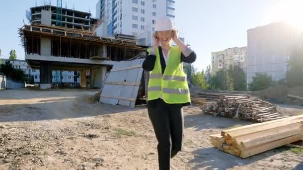 Caminando por el sitio de construcción hermosa dama ingeniero a su equipo de obra de construcción comienzan a bailar todos juntos que llevan todo el uniforme de protección — Vídeos de Stock