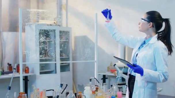 Belle femme scientifique avec la tablette électrique écrire une formule chimique sur la tablette dans le laboratoire de chimie — Video