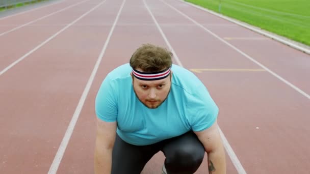 Šťastný a vzrušený obézní muž detailní portrét před kamerou na stadionu na startovní čáře se chystá na tvrdý běh — Stock video