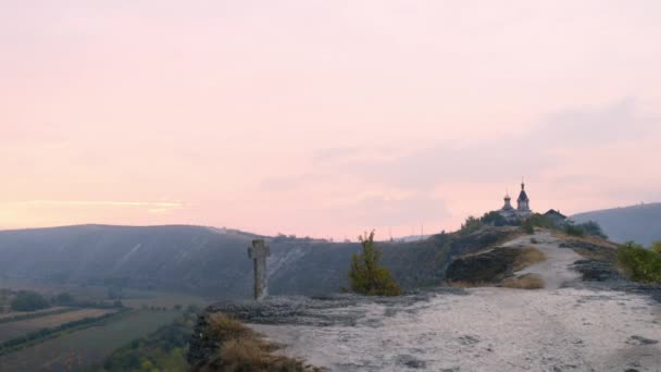 Bella vista del paesaggio naturale e scogliere accanto a un monastero ortodosso con sorprendente cielo rosa. 4k — Video Stock