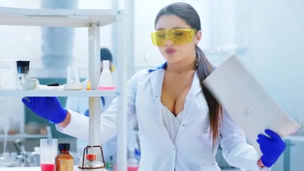 Bella scienziata giovane donna nel laboratorio di chimica molto stanco fine della giornata si ottiene molto caldo indossando uniforme protettiva. Girato su ARRI Alexa Mini. — Video Stock