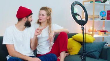 Gülümseyen büyük çiftin sosyal medya hesapları için kanepede canlı yayını var. Videoyu yakalamak için ışık halkası kullanıyorlar.