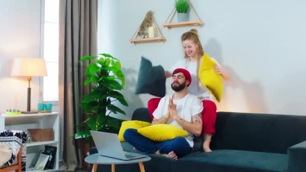 Pasangan ruang tamu modern bersenang-senang bersama mereka bermain dengan bantal di sofa menghabiskan waktu lucu bersama-sama. Ditembak pada ARRI Alexa — Stok Video