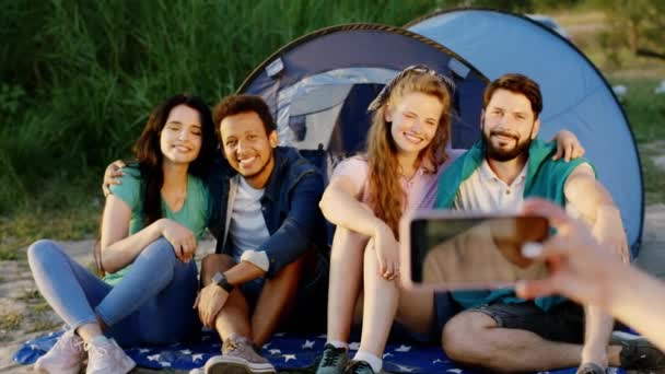 Gambar waktu di piknik teman mengambil beberapa foto dari kelompok multietnis teman sementara mereka duduk di samping tenda dan tersenyum besar. 4k — Stok Video