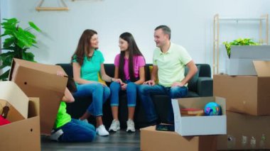 Karizmatik çocuklar ve aileleri yeni bir evde oturma odasındaki anın tadını çıkarırken koltukta saklanmış küçük çocuk dışarı çıktı ve tüm aileye beş çocuk verdi. 4k