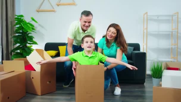 Tempo animado para uma bela família pai e mãe brincando com o menino na nova casa eles aproveitando o momento em um novo lugar — Vídeo de Stock