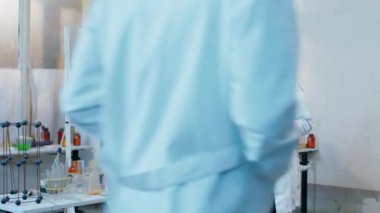 Tıp öğrencileri kimya laboratuvarında birlikte çalışıyorlar koruyucu ekipman giyiyorlar bunun için kimyasal madde kullanarak deney yapıyorlar.