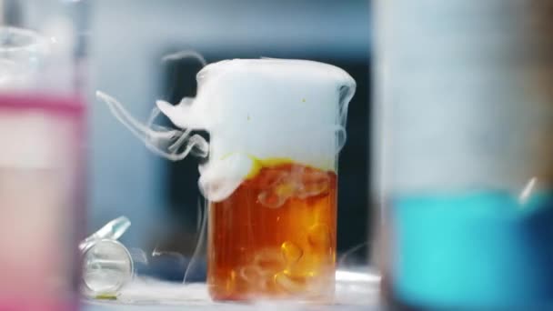Laboratoriumexperimenten met chemische stoffen in de kolf waarbij de gele stof wordt gekookt, rekening houdend met details van dichtbij. 4k — Stockvideo