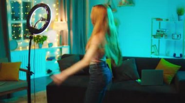 Dansçı kadın etkileyicisi akıllı telefon kayıt önünde bir ışık halkası kullanarak sosyal medya hesabı için bir video kaydediyor.