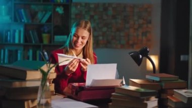 İş yerinde gülümseyen genç bir kadın ara verip bir uçak çatalı kağıdı alır ve komik oyunlar oynar.