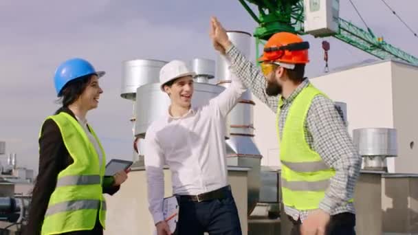 Dobrý stavební tým na vrcholu staveniště dávají pět na sebe po ukončení práce jsou šťastní a nadšení — Stock video