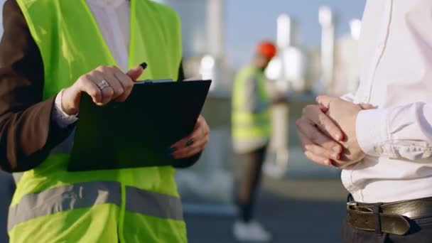 Detalles de primer plano delante de la cámara dos especialistas en construcción en la azotea del sitio de construcción estrechando las manos después de terminar su discusión — Vídeo de stock