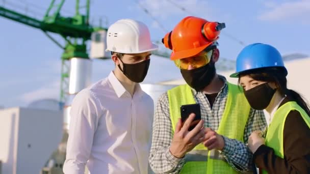 在科罗纳威斯大流行地区，建筑行业的专家们用智能手机观察着他们穿着安全设备和 — 图库视频影像
