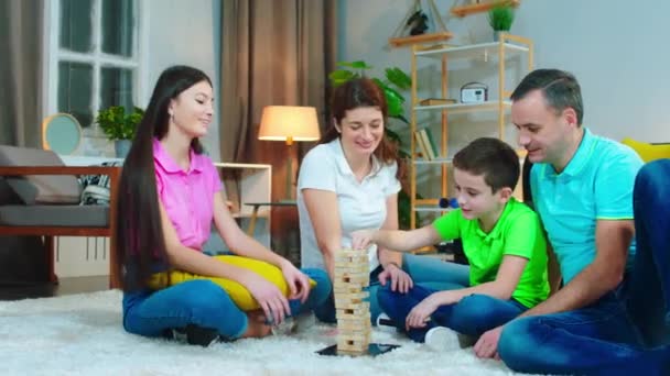 Disfrutando del tiempo en la familia padres y sus hijos jugando un juego de bloques de madera juntos se siente feliz y emocionado — Vídeos de Stock